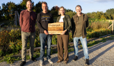 Ron Buiting, Taco Janonius en Cees van den Brink van Parkmakers Utrecht houden samen met Mirjam Sterk een bord van Zusterparken vast