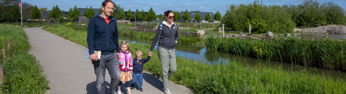 Gezin wandelt temidden van gras en speelplaats in Haarzuilens