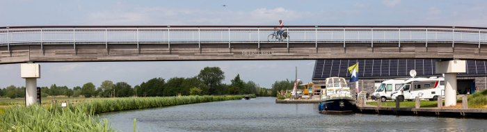 Fietser passeert op de fietsbrug de Hollandse IJssel bij haven Marnemoende