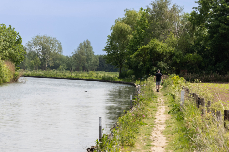 Wandelaar loopt het jaagpad rechts van de Hollandse IJssel