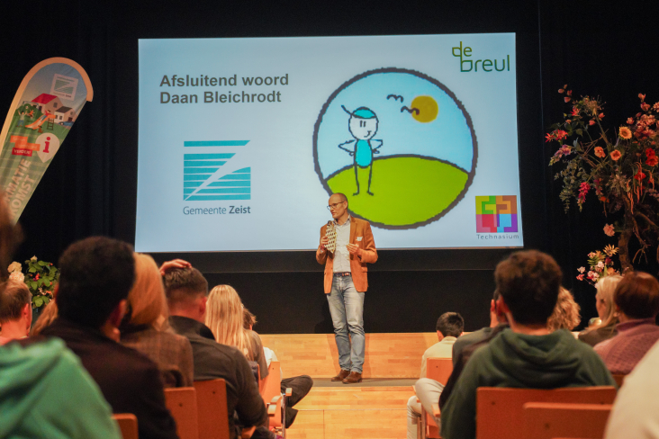 Daan Bleichrodt spreekt vanaf het podium het publiek toe