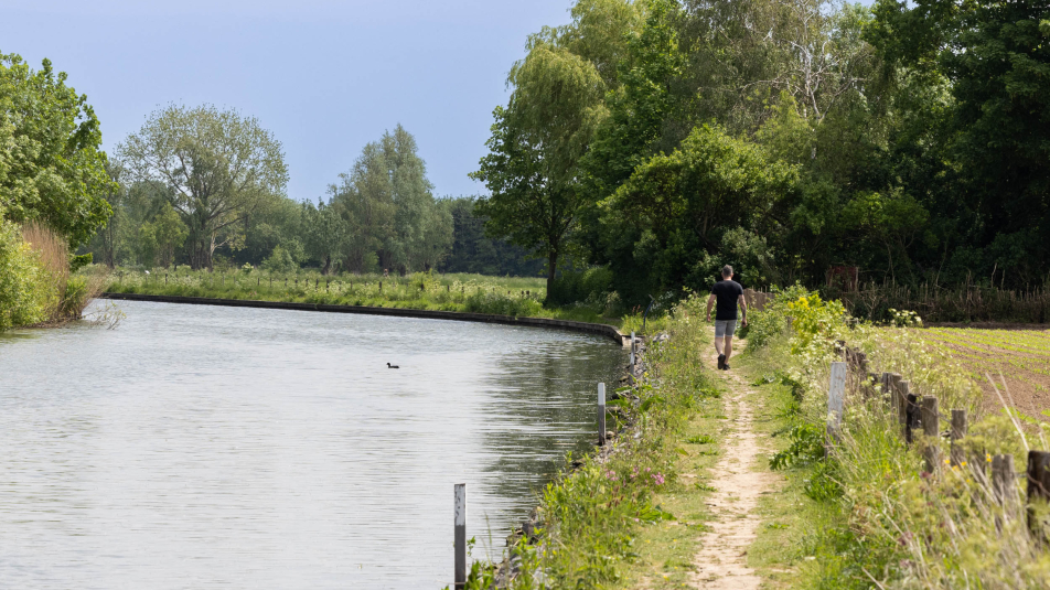 Wandelaar loopt het jaagpad rechts van de Hollandse IJssel