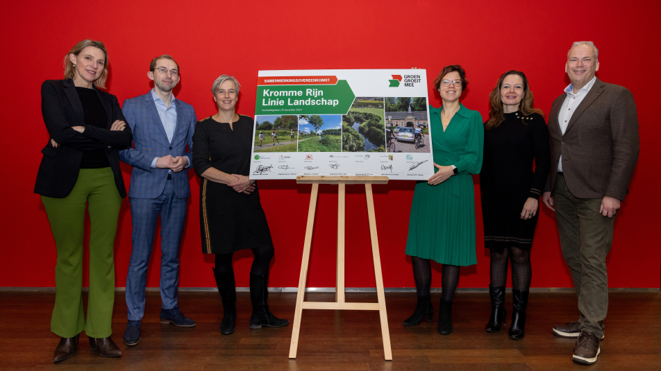 Bestuurders van de gebiedspartijen poseren naast het ondertekeningsbord