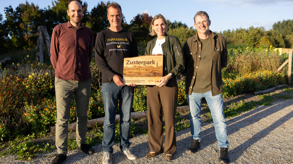 Ron Buiting, Taco Janonius en Cees van den Brink van Parkmakers Utrecht houden samen met Mirjam Sterk een bord van Zusterparken vast